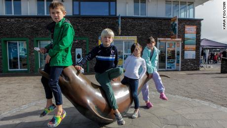Local children hang out on the Fungie statue which was placed in Dingle town in 2000.