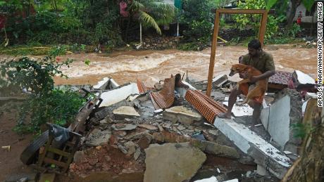 Kāds iedzīvotājs 16.oktobrī Indijā, Keralas štatā, Thoddupuzha, lietusgāžu izraisīto plūdu dēļ, iznīcināto māju vraku vidū tur suni.