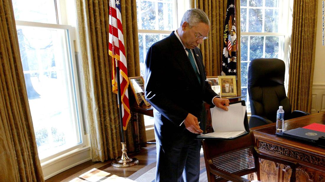 Powell reads over papers while standing in the Oval Office in 2004.