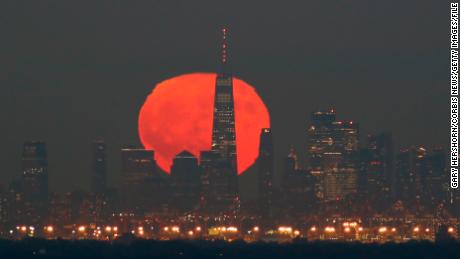 The hunter&#39;s moon, which was also a blue moon last year, rose  behind lower Manhattan and One World Trade Center on October 31, 2020, as seen from Greenbrook Township, New Jersey.