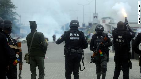 Policemen disperse protesters with tear gas following a demonstration at Lekki toll plaza in Lagos, Nigeria, on Wednesday
