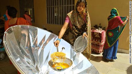 A solar cooker being used to prepare food in Madhya Pradesh, India.