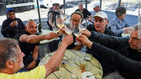 People enjoy a drink at a busy Lygon Street cafe in Melbourne on October 22, following the midnight lifting of coronavirus restrictions in one of the world&#39;s most locked-down cities.