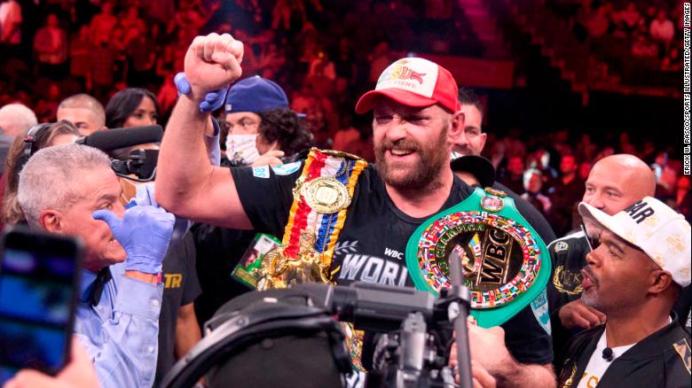 Fury wears his championship belts after defeating Wilder earlier this year. 