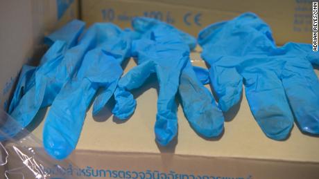 Nitrile gloves shipped to the US by Thai company Paddy the Room Trading Company. These examples, seen by CNN, show clear signs of previous use -- handwriting in pen and other soiling. 