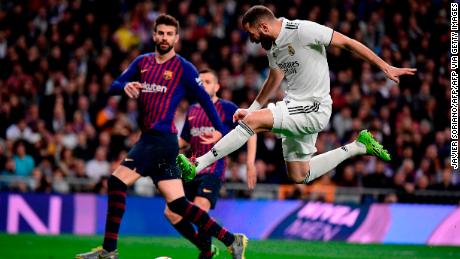 Real Madrid&#39;s French forward Karim Benzema (R) advances with the ball past Barcelona&#39;s Spanish defender Gerard Pique during the Spanish league football match between Real Madrid CF and FC Barcelona at the Santiago Bernabeu stadium in Madrid on March 2, 2019. (Photo by JAVIER SORIANO / AFP)        (Photo credit should read JAVIER SORIANO/AFP via Getty Images)