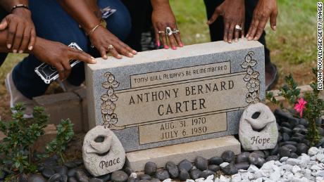 Family members touch the headstone for Anthony Bernard Carter following its unveiling on October 24, 2021 in Hogansville, Georgia. Carter, a 9-year old, was one of the 29 murdered children of Atlanta, who were killed between 1979 and 1981.
