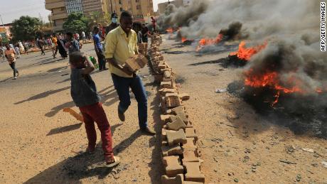 Demonstran membakar ban di ibu kota Sudan, Khartoum, Senin.