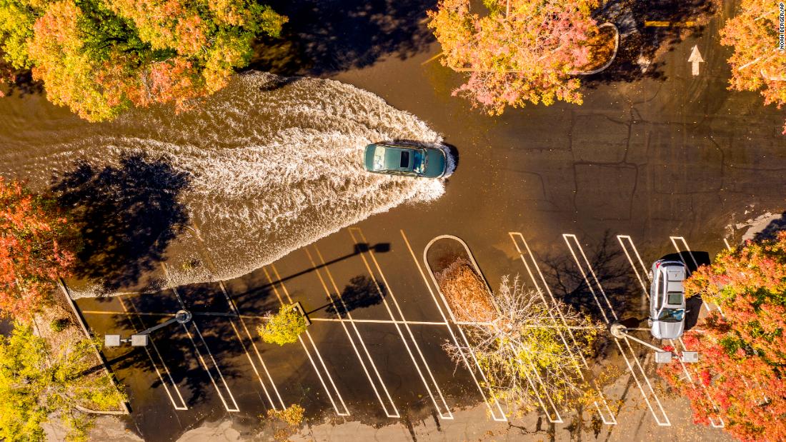 A car crosses a flooded parking lot in Oroville, California, on Monday, October 25.