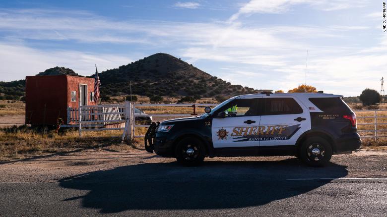 A Santa Fe County Sheriff&#39;s deputy talks to  a security guard at the entrance to the Bonanza Creek Ranch in Santa Fe, N.M.
