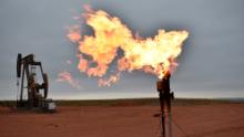 A flare burns natural gas at an oil well on Aug. 26, 2021, in Watford City, N.D. 