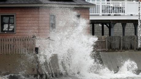 A wave crashes Tuesday into the retaining wall of a home in Fairhaven, Massachusetts, as a powerful nor&#39;easter makes its way across the region.