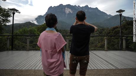 Tourists take photos of Malaysia&#39;s Mount Kinabalu in 2015.