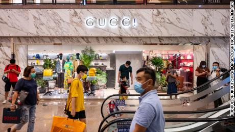 Customers walking past the Gucci store in Hong Kong. 