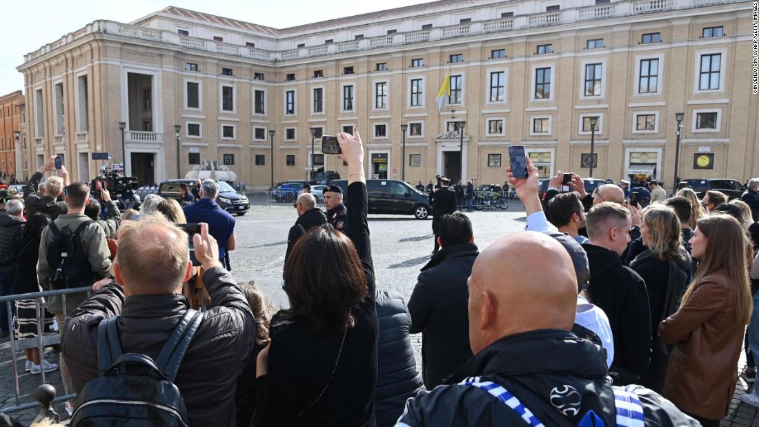People watch Biden&#39;s motorcade in Rome on Friday.