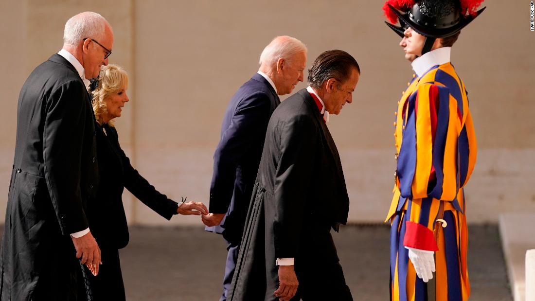 First lady Jill Biden reaches out to touch the President&#39;s hand as they arrive for their meeting with Francis.