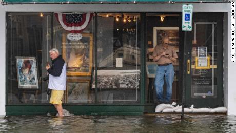 A man walks past an art gallery through floodwaters in downtown Annapolis, Maryland, on Friday.