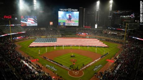 A flag covers outfield during the national anthem before Game 3 of baseball&#39;s World Series between the Houston Astros and the Atlanta Braves Friday, Oct. 29, 2021, in Atlanta. (AP Photo/Ashley Landis)