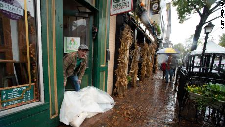 Edward Guerrero checks the height of floodwaters outside of his ice cream shop as the Potomac River overflows its banks, in the historic Old Town section of Alexandria, Virginia, on October 29, 2021. 