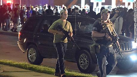 Kyle Rittenhouse, left, carried an AR-15 rifle in Kenosha, Wisconsin on August 25, 2020.