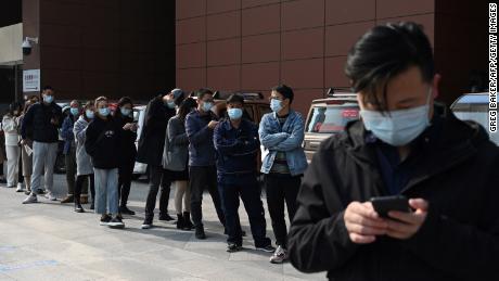 Люди выстраиваются в очередь, чтобы пройти тестирование на коронавирус Covid-19 в больнице в Пекине 29 октября.