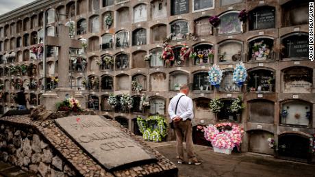 In observance of All Saints Day, a man stands in front of graves decorated with flowers at the Poblenou cemetery of Barcelona, Spain, where many use the holiday to remember deceased loved ones. 