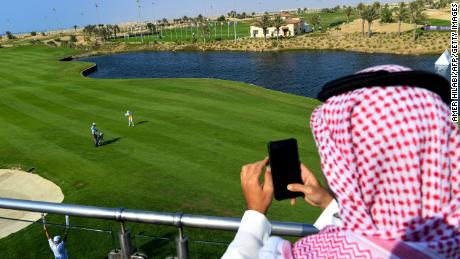 A Saudi man watches a golfer compete in the Saudi Ladies International golf tournament on November 15, 2020.