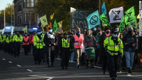 Activists are seen being escorted by police during an Extinction Rebellion protest on Thursday in Glasgow.