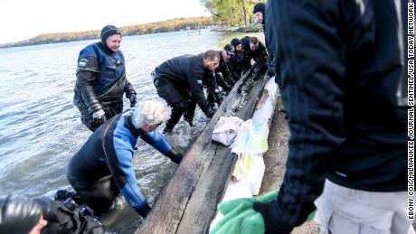 The Dane County Sheriff&#39;s dive team and the Wisconsin Historical Society team recover the 1,200 year old canoe from the bottom of Lake Mendota at Spring Harbor Beach in Madison, Wis.