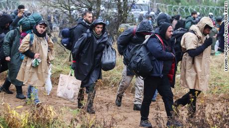 Migrants carry their belongings as they make their way towards the Poland-Belarus border on Monday. 