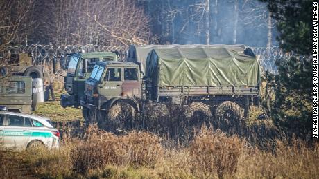 Polish army vehicles are parked along the barbed wire near the Kuznica border crossing on Tuesday. 