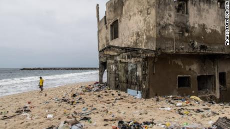 LAGOS, NIGERIA - OCTOBER 27, 2021: Delabitating buildings from the rising waters remain partially buried in sand along the beach. CREDIT: Yagazie Emezi for CNN.