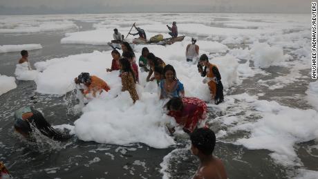 Toxic foam coats sacred river in India as Hindu devotees bathe in its waters