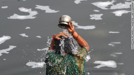 Devotees bathe on the eve of Chhatt Pooja in the toxic foam in the Yamuna River on November 9, 2021 in New Delhi, India. 