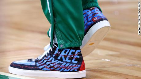 Enes Kanter mengenakan sepatu yang mengkritik China sebelum pertandingan kandang Celtics melawan Toronto Raptors pada 22 Oktober 2021.