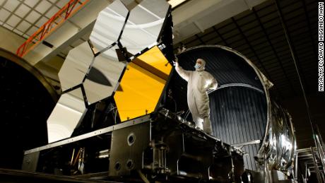 El ingeniero jefe de pruebas ópticas examina seis secciones de espejos primarios, que son componentes importantes del telescopio espacial James Webb de la NASA.