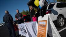 Recruiters speak with a potential applicants during a tail gate job fair in Leesburg, Virginia on October 21, 2021. 