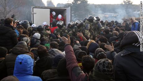 Migrants gather to receive humanitarian aid in a camp on the Belarusian-Polish border in Belarus&#39; Grodno region on November 12, 2021. 