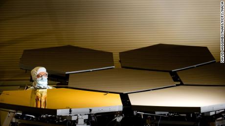 Ball Aerospace optics technician Scott Murray inspects the telescope's first gold primary mirror segment.