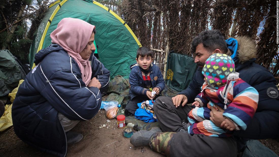 A family rests at a camp set up in the Grodno region on Saturday, November 13.