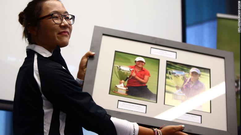 Ko is presented with a photo board displaying her wins following her arrival at Auckland International Airport on September 18, 2013 in New Zealand.