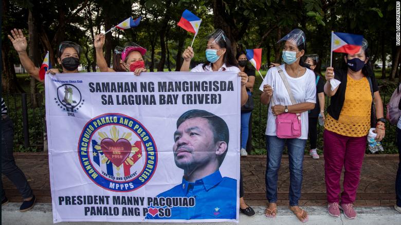 Supporters of Philippine senator Manny Pacquiao welcome him as he arrives to file his certificate of candidacy for President on October 1, 2021.