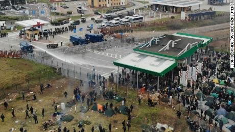 Polish officers use water cannon on migrants gathered at the Bruzgi-Kuznica checkpoint.
