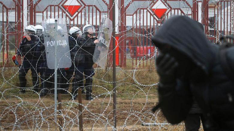 Polonyalı askerler, 16 Kasım 2021 Salı günü Belarus-Polonya sınırındaki Belarus-Polonya sınırında göçmenler ve Polonya sınır muhafızları arasındaki çatışmalar sırasında dikenli tellerin diğer tarafında görülüyor.