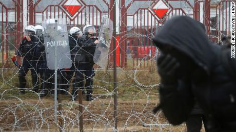 Polish border forces are seen through the barbed wire border fence during clashes Tuesday.
