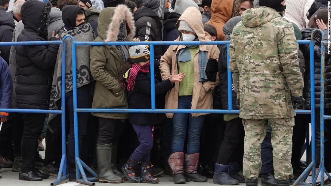 Migrants line up near the border crossing with Poland to get food and drink. 