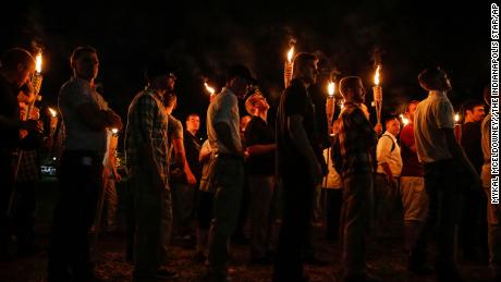 FILE - In this Aug. 11, 2017, file photo, multiple white nationalist groups march with torches through the University of Virginia campus in Charlottesville, Va. A federal judge has issued an arrest warrant for neo-Nazi podcaster Robert &quot;Azzmador&quot; Ray, who promoted and attended the white nationalist rally in Virginia that erupted in violence in 2017. (Mykal McEldowney/The Indianapolis Star via AP, File)
