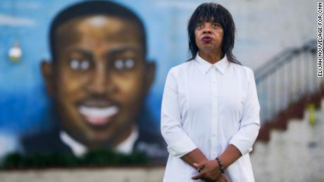 Aundra Fuller stands in front of a mural of Ahmaud Arbery outside the Brunswick African American Cultural Center.