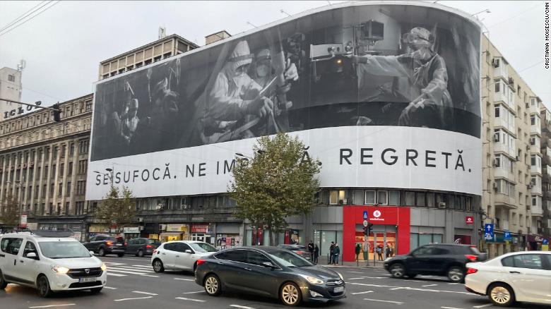 A banner in Bucharest shows medics working on Covid-19 patients with this message: &quot;They&#39;re suffocating. They&#39;re begging us. They&#39;re regretting.&quot;