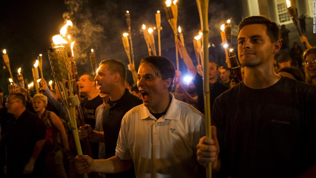 White supremacists chant at counter protesters after marching through the University of Virginia campus with torches in Charlottesville, Virginia, on August 11, 2017.